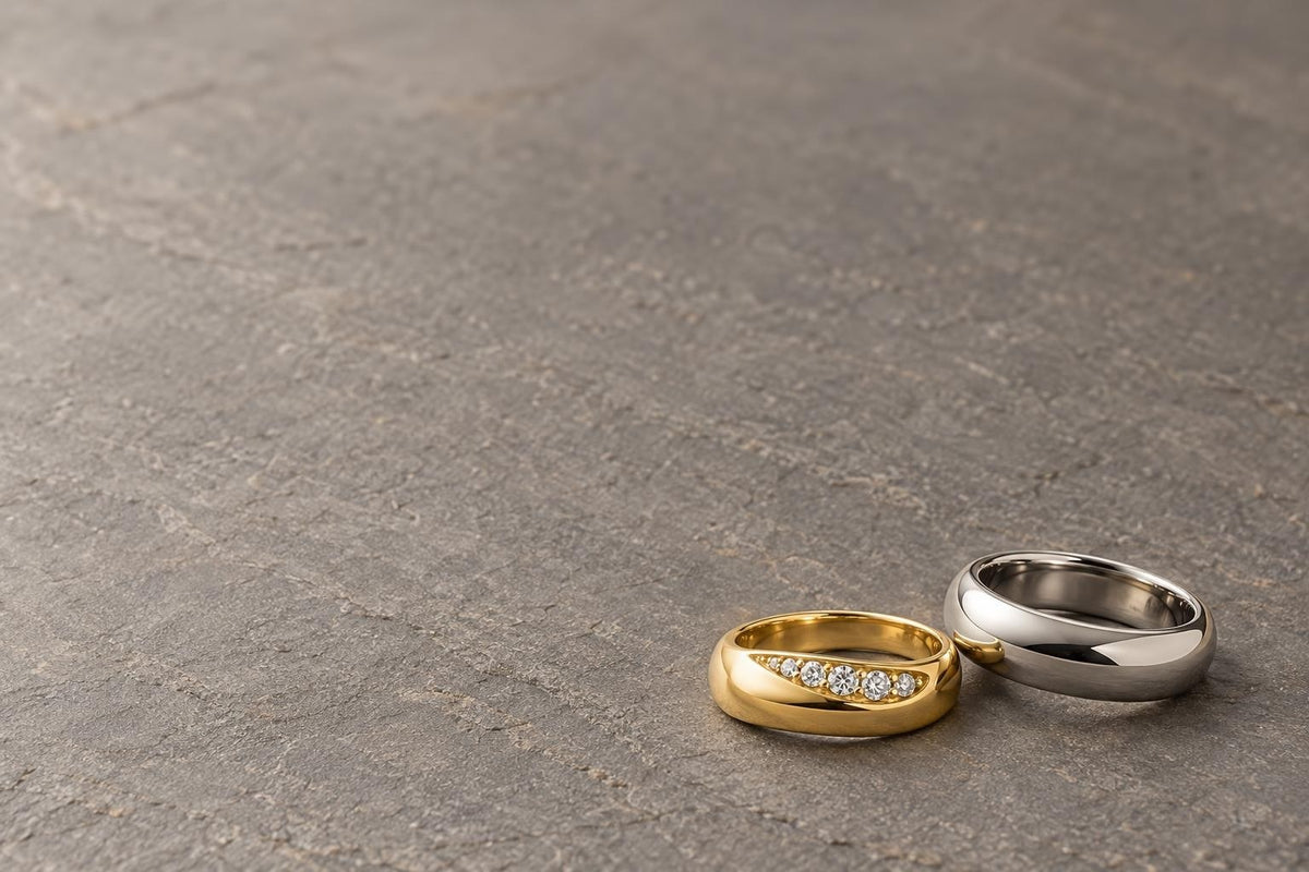 Men's lab-grown diamond wedding band in 14K yellow gold beside a titanium band - Sophia Jewelers